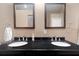 Bathroom featuring double sinks with black countertops and a view into the shower at 3863 Albin Ave, North Port, FL 34286