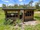 Rustic chicken coop with wooden structure and wire mesh enclosures, surrounded by greenery at 3863 Albin Ave, North Port, FL 34286