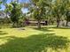 Exterior view of a rustic barn-style home with a large yard and mature trees at 3863 Albin Ave, North Port, FL 34286