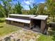 Exterior view of a barn-style structure with a metal roof and outdoor spaces at 3863 Albin Ave, North Port, FL 34286