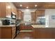 A spacious kitchen with an island, stainless steel appliances, wood cabinets and a view of the window at 3863 Albin Ave, North Port, FL 34286