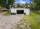 Outbuilding with an open garage bay and large gravel parking area at 3863 Albin Ave, North Port, FL 34286