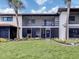 Condo exterior featuring a manicured lawn, palm trees, and a screened-in porch, offering a blend of indoor/outdoor living at 401 Airport E Ave # 304, Venice, FL 34285