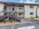 Building exterior with stairs leading to upper units and parking space, showcases practical design and accessibility at 401 Airport E Ave # 304, Venice, FL 34285