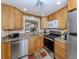Open kitchen with granite countertops, stainless steel appliances, and light wood cabinets at 401 Airport E Ave # 304, Venice, FL 34285