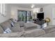 Bright living room boasts a large sectional sofa, and sliding doors to a screened lanai, perfect for relaxation at 401 Airport E Ave # 304, Venice, FL 34285