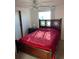 Cozy bedroom with a wooden bed frame and a bright red quilt at 411 Vasto Dr, Venice, FL 34285