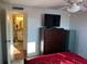 Cozy bedroom featuring a dresser with a TV and ensuite bathroom at 411 Vasto Dr, Venice, FL 34285