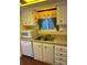 Kitchen features white cabinets, stainless sink and view into another room at 411 Vasto Dr, Venice, FL 34285