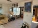 Well-lit living area featuring neutral carpeting, comfortable seating, and stylish décor at 411 Vasto Dr, Venice, FL 34285