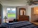 Bright main bedroom features a ceiling fan, dresser, and an attached bathroom with a window overlooking the yard at 411 Vasto Dr, Venice, FL 34285