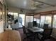 Enclosed porch with ceiling fan, dining table, and ample seating, perfect for relaxing and entertaining at 411 Vasto Dr, Venice, FL 34285