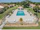 Aerial view of the community pool, lined with palms, and featuring lounge areas and covered pavilion at 4176 Summertree Rd, Venice, FL 34293