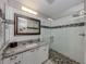 Modern bathroom featuring a glass-enclosed shower with a stone floor and decorative tile accents at 4176 Summertree Rd, Venice, FL 34293