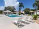Relaxing community pool area featuring lounge chairs, covered pavilion, and lush tropical landscaping at 4176 Summertree Rd, Venice, FL 34293