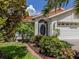 Inviting home exterior with a tile roof, a two-car garage, and lush, verdant landscaping at 4176 Summertree Rd, Venice, FL 34293