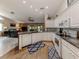 Modern kitchen featuring white cabinets, stainless appliances, and a view of an open-concept living area at 4176 Summertree Rd, Venice, FL 34293