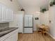 Eat-in kitchen features white cabinets, stainless steel refrigerator, and a small breakfast table at 4176 Summertree Rd, Venice, FL 34293