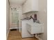 Functional laundry room with modern washer, sink, storage and wooden floors at 4176 Summertree Rd, Venice, FL 34293