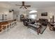 Open-concept living room connected to the kitchen, features a ceiling fan and leather furniture at 4176 Summertree Rd, Venice, FL 34293
