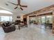 Bright and airy living room with tile floors, ceiling fan, and wood accent wall adjacent to screened-in lanai at 4176 Summertree Rd, Venice, FL 34293
