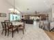 Open-concept living space with tiled floors, a dining area, comfortable seating, and access to modern kitchen at 4176 Summertree Rd, Venice, FL 34293
