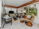 Cozy sunroom with wicker furniture, tile floors, and large windows offering views of the backyard at 4176 Summertree Rd, Venice, FL 34293