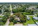 Aerial view of a property with mature trees and a screened-in pool at 4227 Blossom Rd, Venice, FL 34293