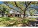 Charming single-story home featuring lush landscaping and a large shade tree in the front yard at 4227 Blossom Rd, Venice, FL 34293