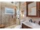 Elegant bathroom featuring a glass-enclosed shower, marble vanity, and bronze fixtures at 4260 Wordsworth Way, Venice, FL 34293