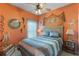 Nautical themed bedroom with orange walls, queen bed, and ceiling fan at 4260 Wordsworth Way, Venice, FL 34293
