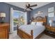 Cozy bedroom features wood furniture, a ceiling fan, and a large window with exterior views at 4260 Wordsworth Way, Venice, FL 34293