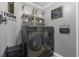 Well-organized laundry room equipped with modern washer and dryer, shelving, and charming decor at 4260 Wordsworth Way, Venice, FL 34293