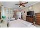Bright main bedroom with ceiling fan, lounge, large TV, and access to ensuite bathroom and dining room at 4260 Wordsworth Way, Venice, FL 34293