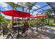 Outdoor patio featuring comfortable seating, lush landscaping, and serene water views at 4260 Wordsworth Way, Venice, FL 34293