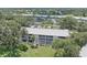 Aerial view of condo building surrounded by lush trees, landscaping, and community features at 437 Cerromar Ln # 414, Venice, FL 34293