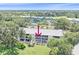 Aerial view of condo building nestled within lush landscaping and adjacent to golf course at 437 Cerromar Ln # 414, Venice, FL 34293