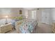 Cozy bedroom with floral bedding, soft lighting, and ensuite bathroom access at 437 Cerromar Ln # 414, Venice, FL 34293