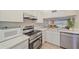 Updated kitchen boasts white cabinets, stainless steel appliances, and quartz countertops at 437 Cerromar Ln # 414, Venice, FL 34293
