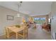 Bright living and dining space with neutral carpet, comfortable furnishings, and large windows showcasing golf course views at 437 Cerromar Ln # 414, Venice, FL 34293