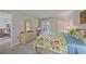 Bedroom with floral bedding, dresser, and a view of the outdoor area at 437 Cerromar Ln # 414, Venice, FL 34293