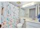 Bathroom featuring a colorful shower curtain, toilet, and a single sink vanity with a large mirror at 437 Cerromar Ln # 513, Venice, FL 34293