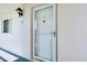 A clean, well-maintained front door of a condo unit, illuminated by an exterior light fixture at 437 Cerromar Ln # 513, Venice, FL 34293