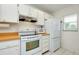Bright kitchen featuring white appliances, tiled floor, and ample cabinet space at 437 Cerromar Ln # 513, Venice, FL 34293