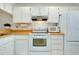 Efficient kitchen with white cabinets, appliances and a practical layout at 437 Cerromar Ln # 513, Venice, FL 34293