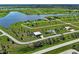 This aerial view shows a house's location within a neighborhood by a lake, new construction, and various roads at 48 Lark Dr, Placida, FL 33946