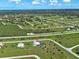 An aerial view of a home surrounded by green spaces with a paved road in a rural setting at 48 Lark Dr, Placida, FL 33946