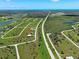 An aerial view highlights a home's location with a long road and scattered palm trees in a green, rural area at 48 Lark Dr, Placida, FL 33946