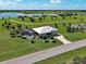 Expansive aerial view of a home with lush green lawn, screened in pool, lake view, and long driveway at 48 Lark Dr, Placida, FL 33946