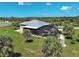 This aerial view showcases a beautiful home with a screened-in pool, complemented by lush palm trees at 48 Lark Dr, Placida, FL 33946